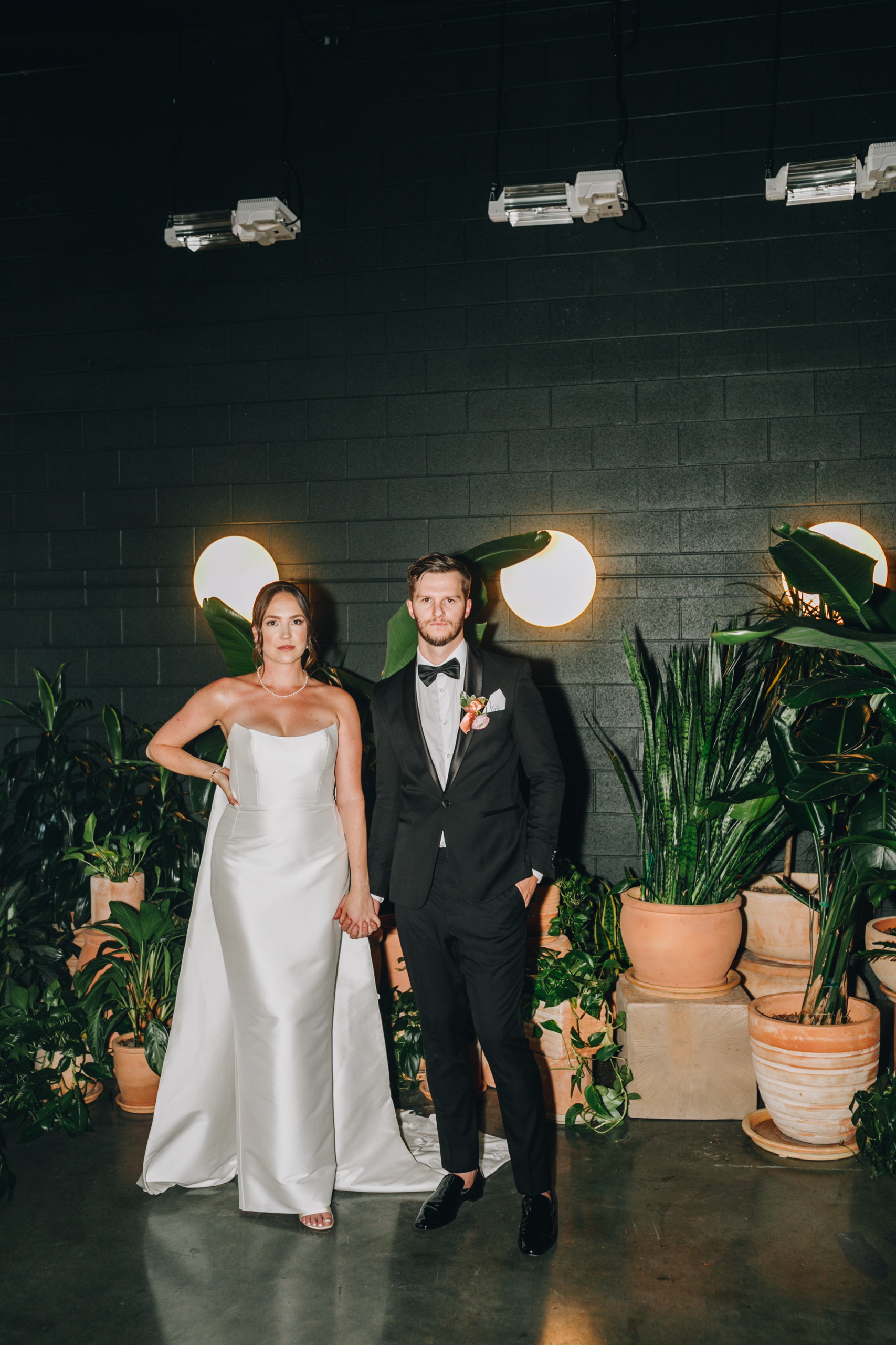 couple standing in front of plants at Paradise at The Guild wedding venue captured by Kansas City Photographer Kymberly Janelle Photogrpahy